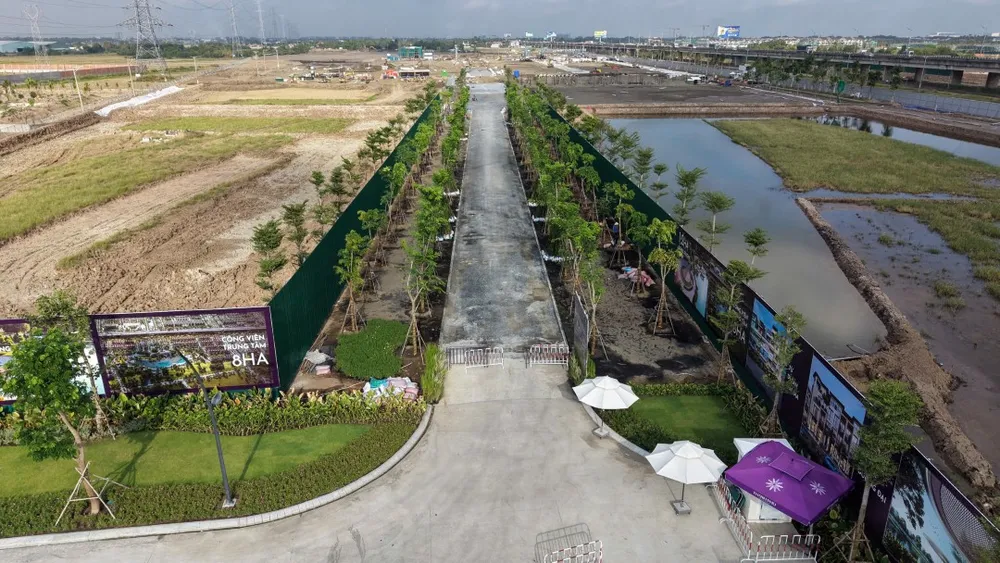 Trục đường dẫn vào Công viên trung tâm được phủ xanh bởi hai hàng cây bóng mát và hệ thống hoarding bảo vệ.